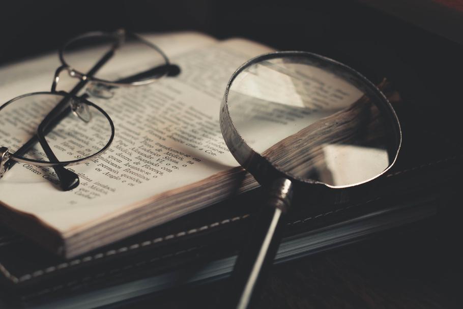 Book, glasses, and a magnifying glass